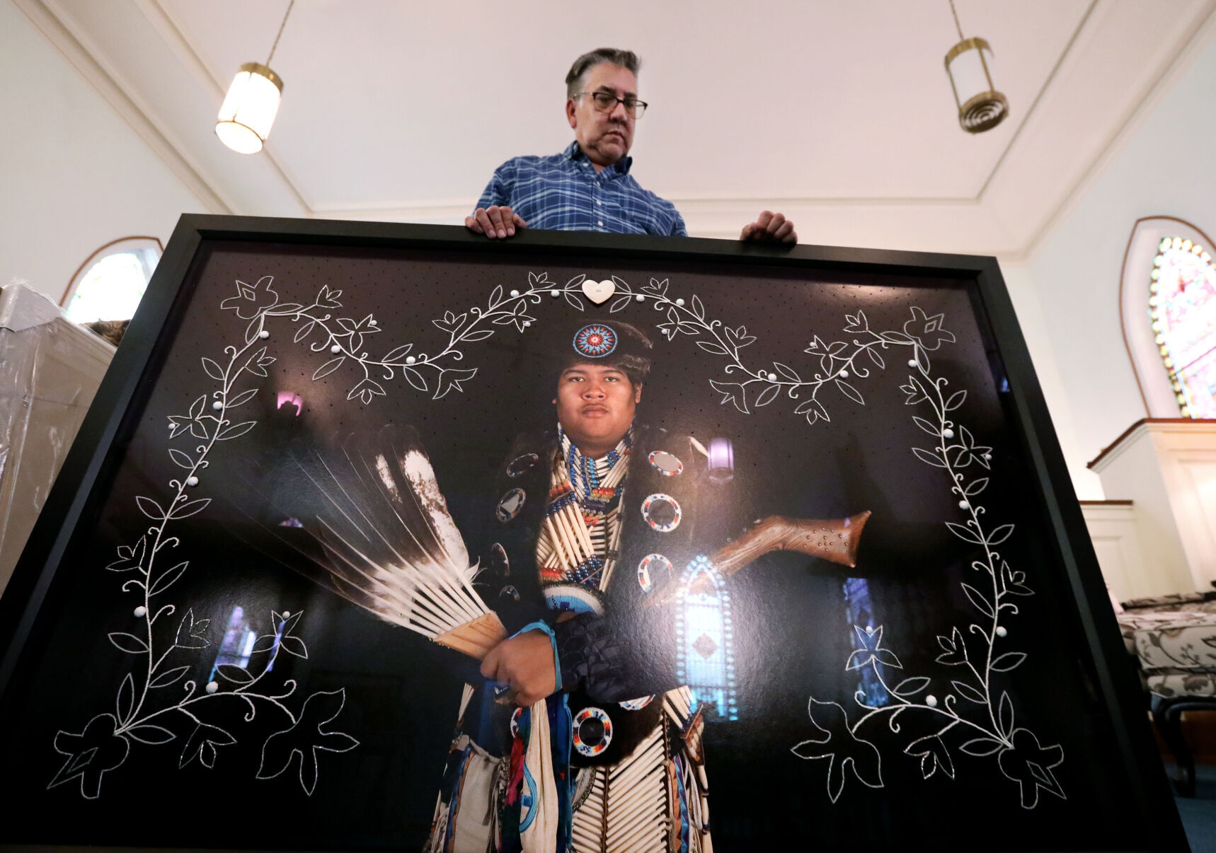 Tom Jones holding portrait in "Strong Unrelenting Spirits" series